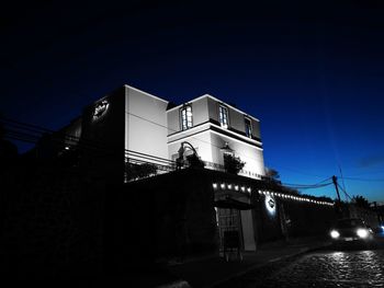 Low angle view of illuminated building against sky at night