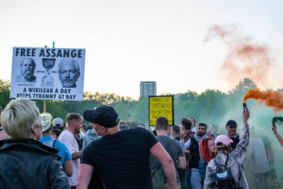 Rear view of people standing in city against sky