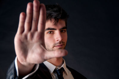 Portrait of young man against black background