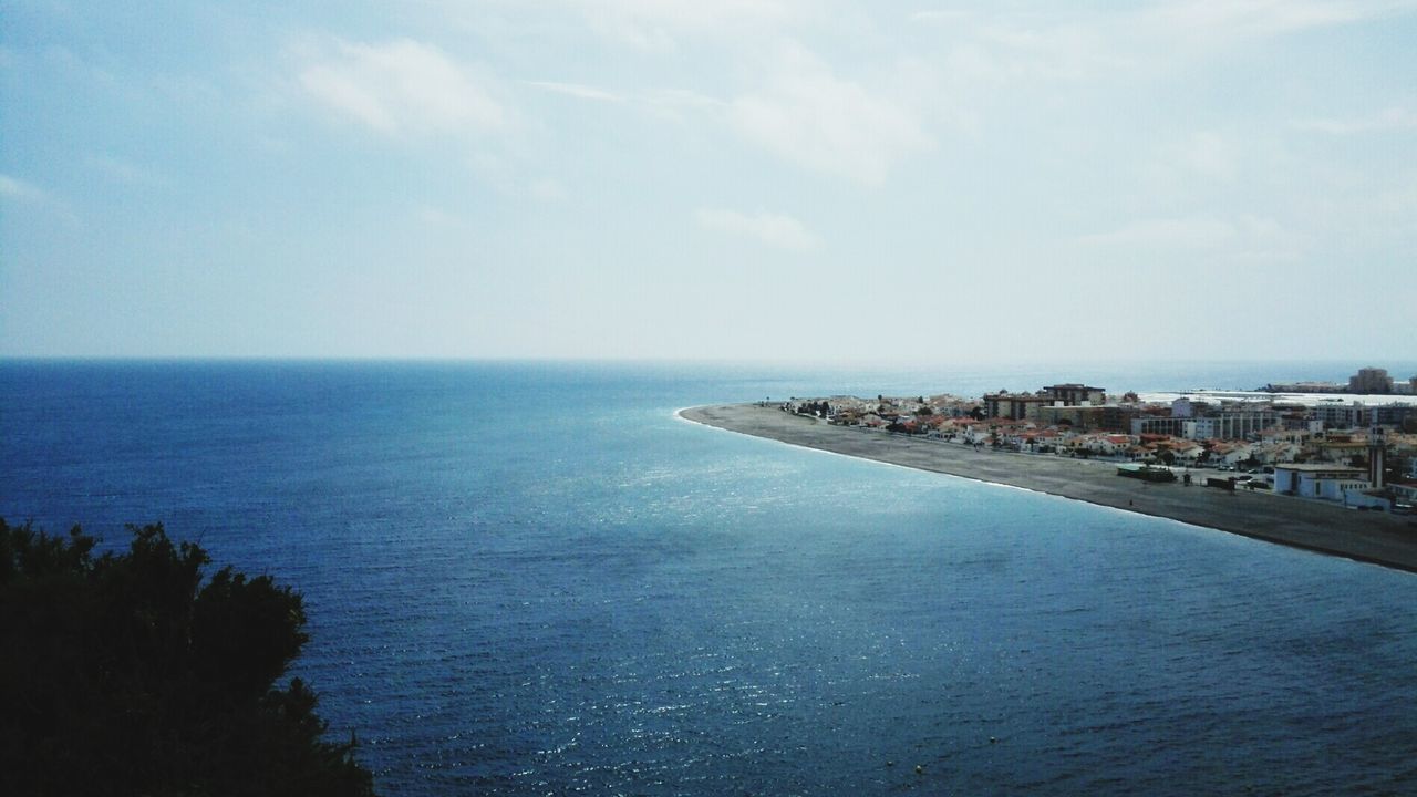 sea, water, horizon over water, sky, scenics, tranquil scene, tranquility, beauty in nature, waterfront, blue, nature, built structure, architecture, building exterior, idyllic, cloud - sky, cloud, coastline, seascape, high angle view