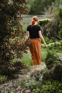 Happy ginger hair woman walking barefoot in the park or garden. freedom and healthy way of life