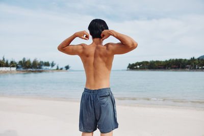 Rear view of man standing at beach