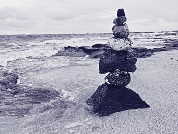 Sculpture on beach against sky