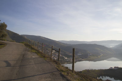 Road leading towards mountains against sky