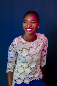 Portrait of a smiling young woman against gray background