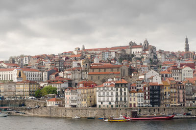 River amidst buildings in city against sky