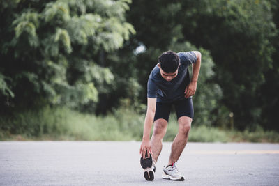 Rear view of man skateboarding on road