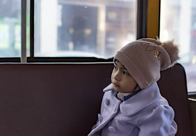 Cute boy looking through window at home