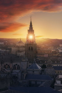 Buildings in city against sky during sunset