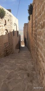 Narrow alley amidst buildings against sky