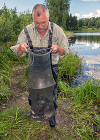 Portrait of man standing by lake