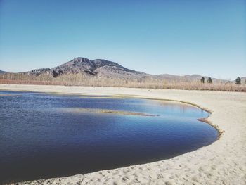 Scenic view of lake against clear blue sky