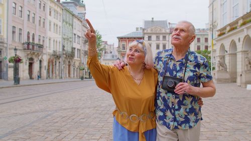 Portrait of smiling couple standing against buildings