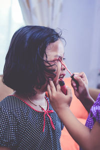 Portrait of young woman blowing nose