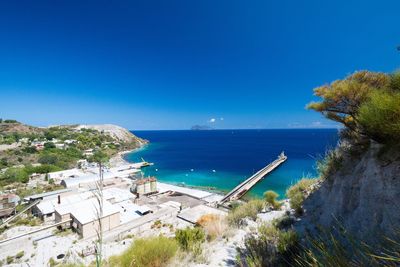 High angle view of swimming pool by sea against clear blue sky