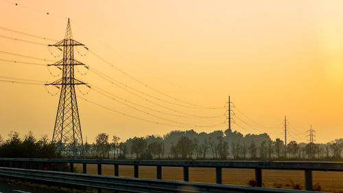 Electricity pylon against sky during sunset