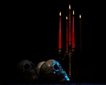 Close-up of burning candle against black background