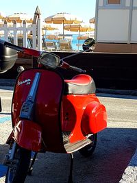 Red motor scooter on road in city