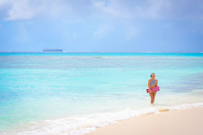 Woman standing on beach against sky