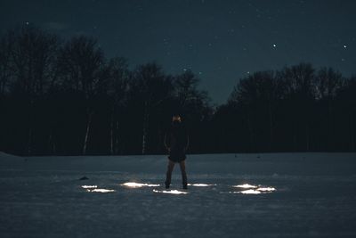 Man standing field at night during winter