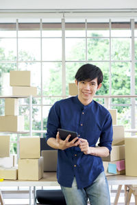 Portrait of a smiling young man holding mobile phone