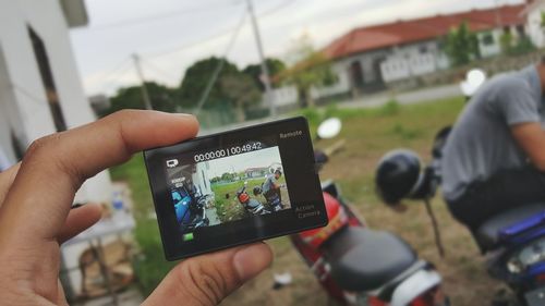 Midsection of man photographing with mobile phone