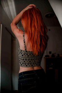 Rear view of woman with redhead standing at home