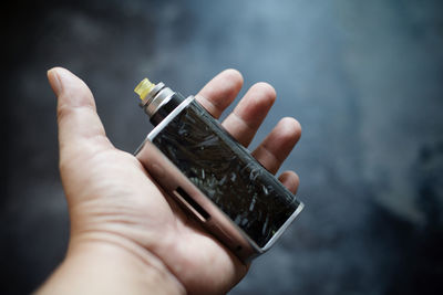 Close-up of cropped hand holding electronic cigarette