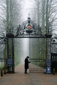 Man standing by gate in snow