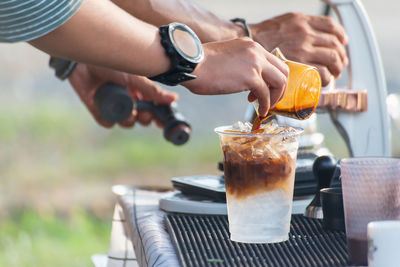 Midsection of man holding coffee cup on table