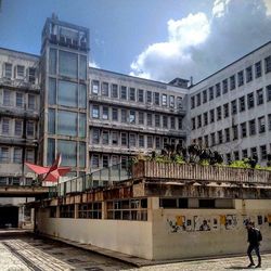 Buildings in city against cloudy sky