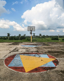 Information sign on road by field against sky