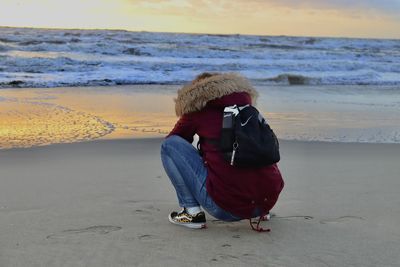 Rear view of woman walking on beach