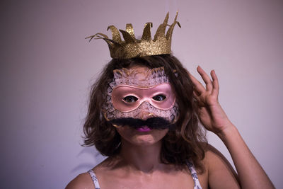 Portrait of woman wearing crown and mask with mustache