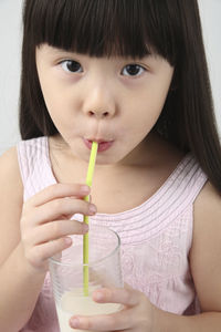 Close-up portrait of cute girl drinking milk from straw