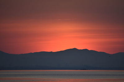 Scenic view of silhouette mountains against romantic sky at sunset