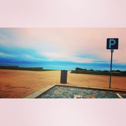 Low angle view of road sign against blue sky