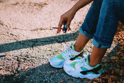 Low section of woman wearing shoes on ground
