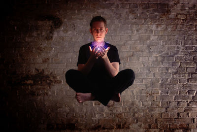 Young woman standing on wall