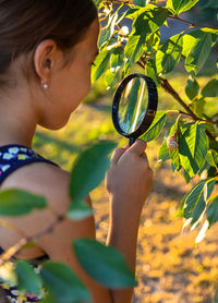 Close-up of woman holding magnifying glass