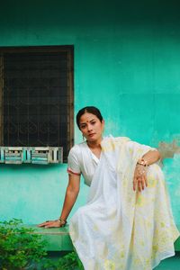 Rear view of woman standing against blue wall