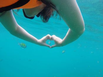 Woman swimming with heart shape undersea