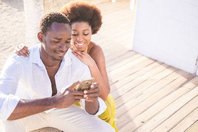 Young man with woman using phone
