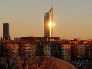 Buildings in city against sky during sunset