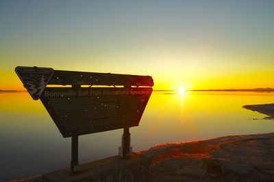 Information sign at bonneville salt flats against sky during sunset