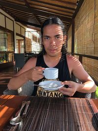 Portrait of man drinking coffee in restaurant