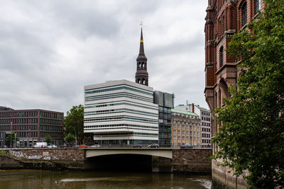 Canal amidst buildings in city against sky