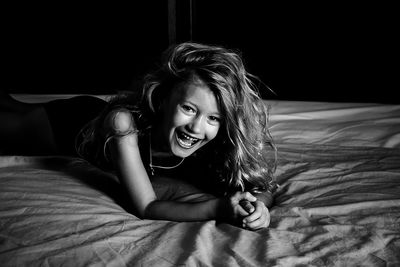Smiling girl lying on bed at home