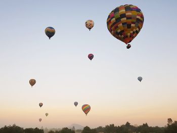 Low angle view of hot air balloons against sky during sunrise