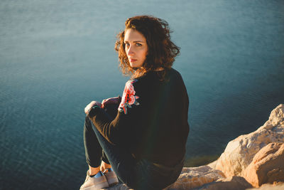 Portrait of beautiful woman standing at sea shore